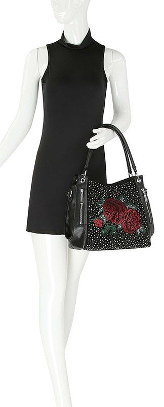 A beautiful way to shine up any look, fashion handbag features dual front pockets, tassel accent and shimmering rhinestone crystals in a rose design.